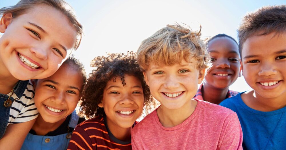 Group of kids gathered in a circle smiling