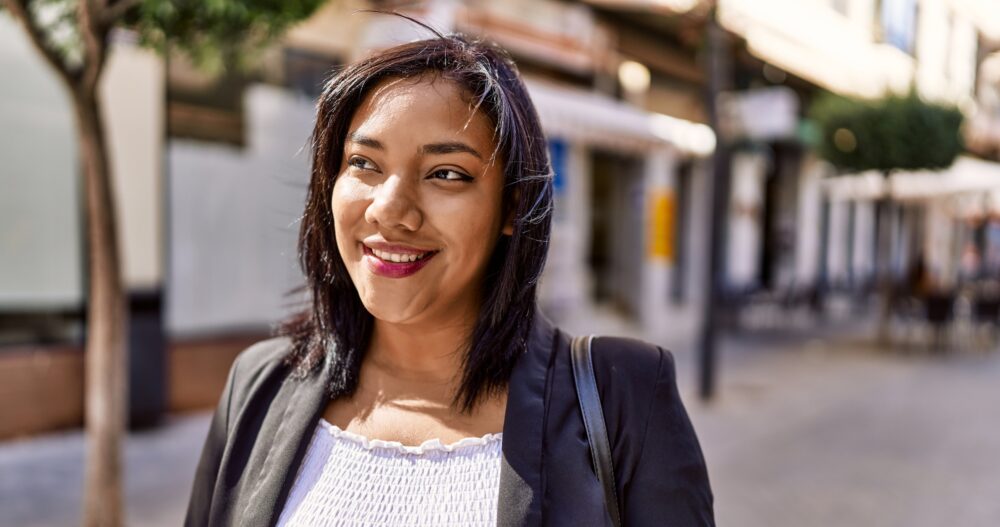 Woman in professional clothing standing outside smiling